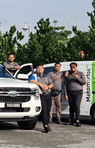 Metamorfos Solution team standing beside company vehicles outdoors.
